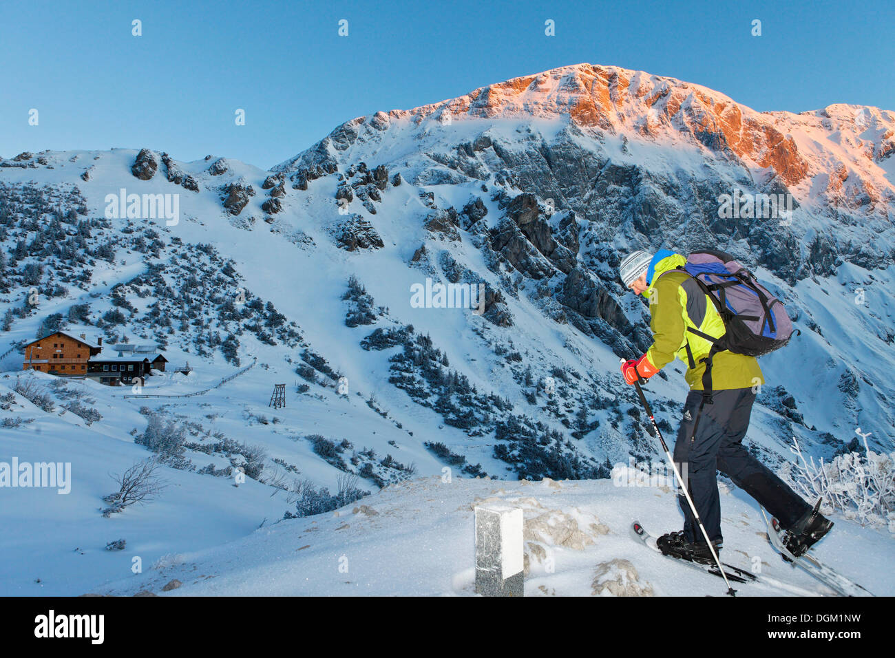 Mann Schneeschuhwandern in Richtung Carl-von-stahl Haus am Torrener Joch, Sonne auf hohes Brett Berg, eine Hütte aus der Stockfoto