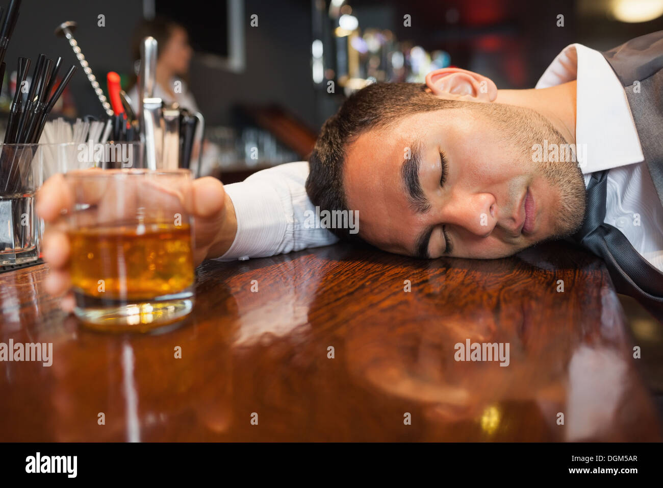 Betrunken und unbewussten Geschäftsmann liegend auf einer Theke Stockfoto