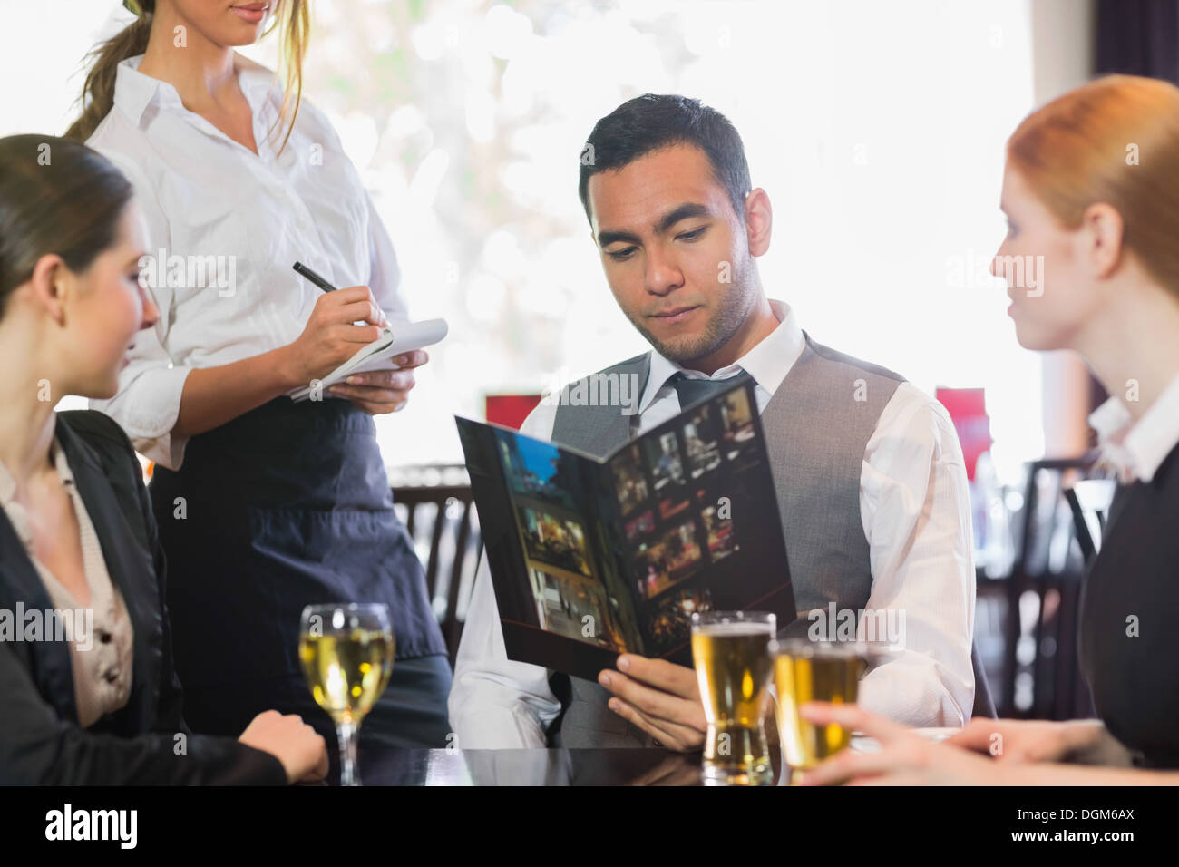 Gut aussehend Geschäftsmann Abendessen von Kellnerin bestellen Stockfoto