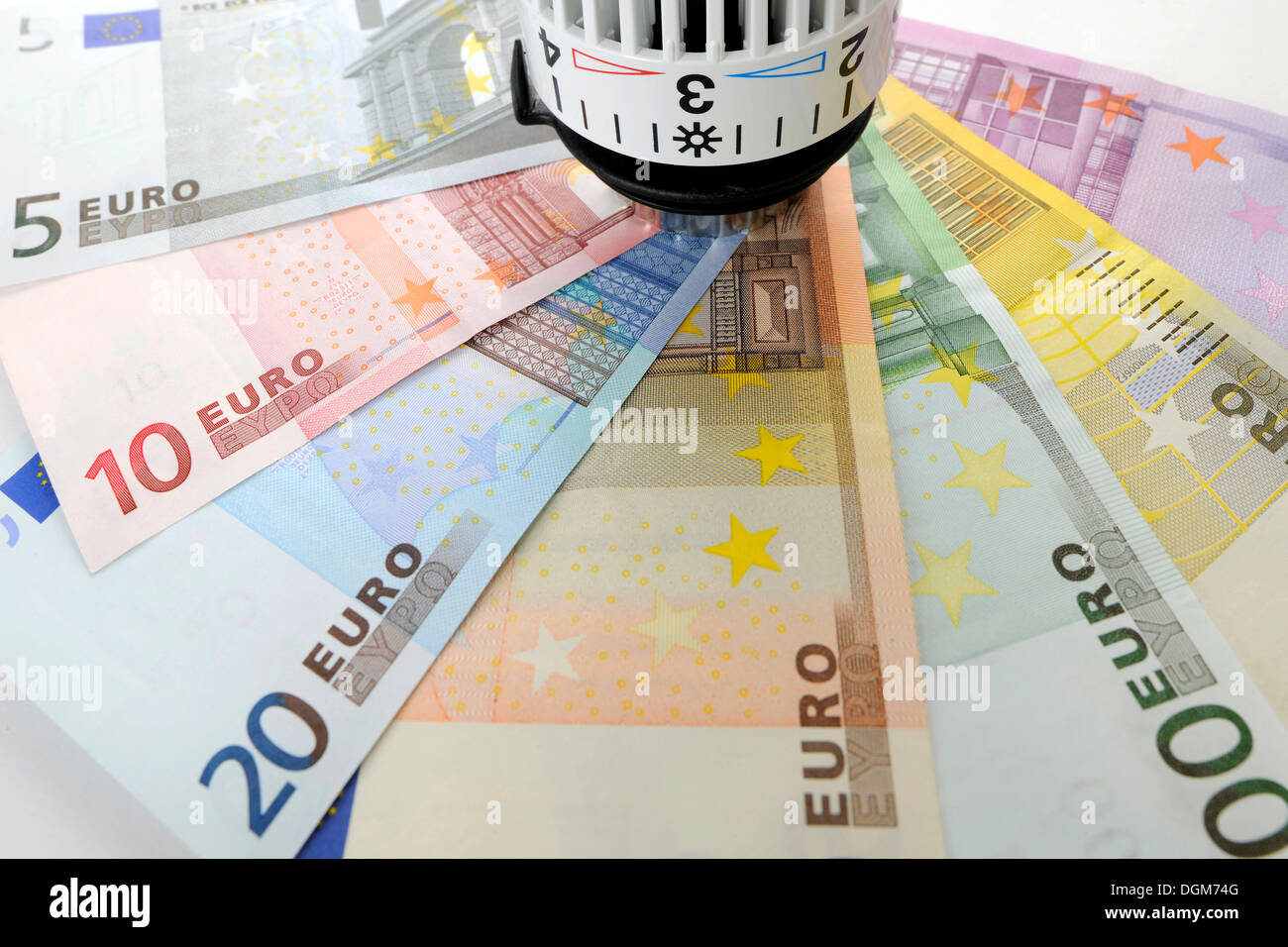 Heizkörperventil mit Euro-Banknoten, symbolisches Bild für Heizkosten, Energiekosten Stockfoto