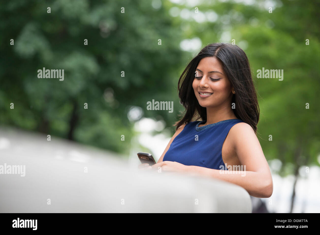 Business-Leute. Eine Frau mit langen schwarzen Haaren, trägt ein blaues Kleid. Stockfoto