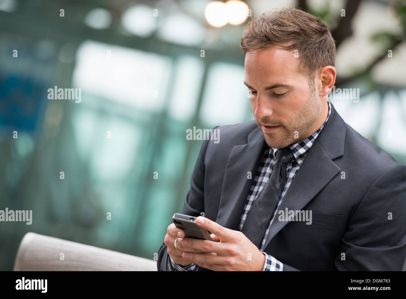 Business-Leute. Ein Mann im Anzug. Ein Mann mit kurzen roten Haaren und einem Bart, trägt einen Anzug auf seinem Handy. Stockfoto