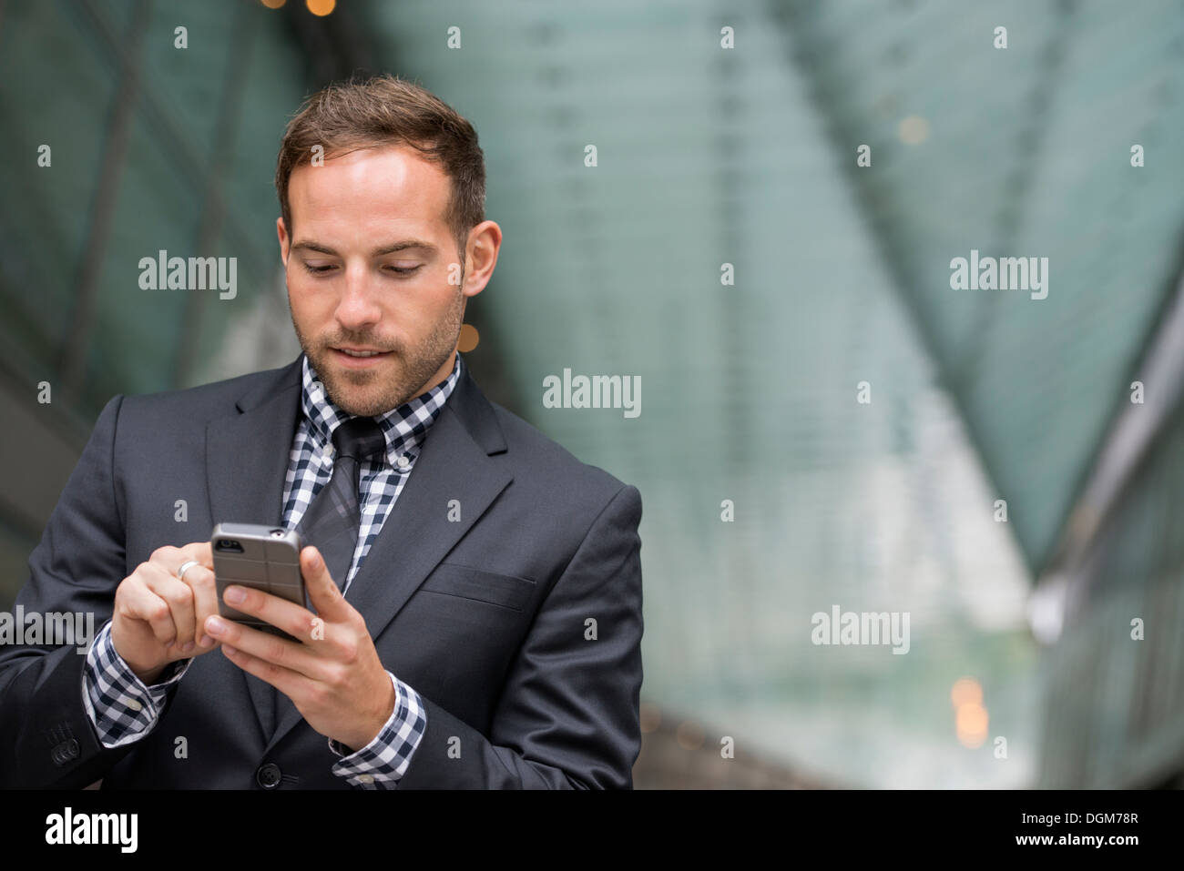 Business-Leute. Ein Mann im Anzug. Ein Mann mit kurzen roten Haaren und einem Bart, trägt einen Anzug auf seinem Handy. Stockfoto
