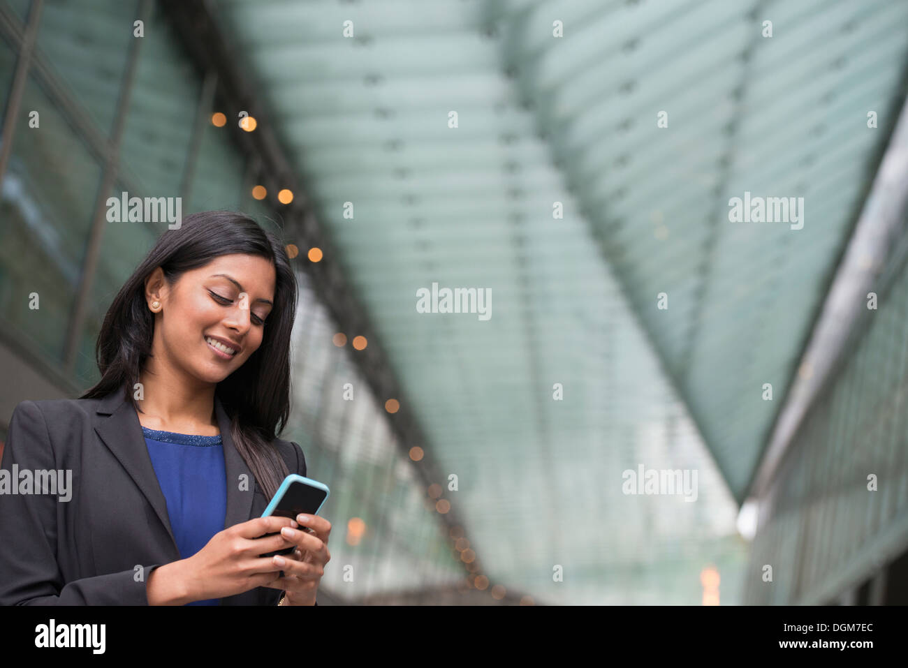 Business-Leute. Eine junge Frau in einem blauen Kleid und grauen Jacke. Stockfoto