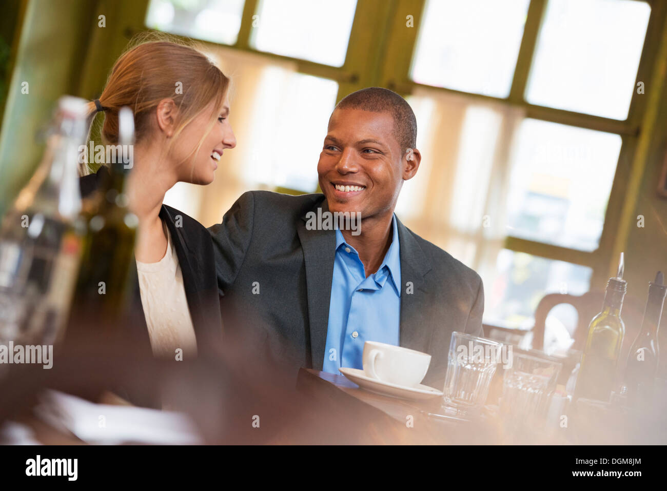 Ein paar, ein Geschäftsmann und Geschäftsfrau in einem Coffee-Shop oder Café, nebeneinander sitzen. Eine Besprechung oder einen Termin. Stockfoto