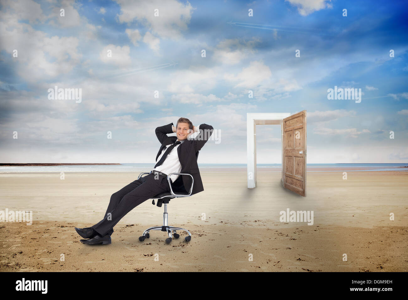 Geschäftsmann auf Drehstuhl am Strand Stockfoto