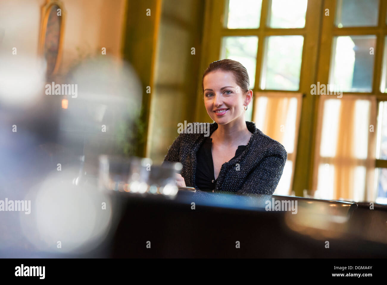 Geschäftsleute im Freien. Eine Frau allein an einem Tisch in einem Café oder Restaurant zu sitzen. Stockfoto