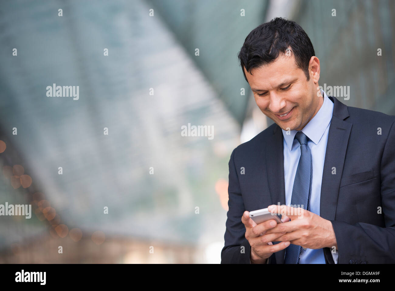 Business-Leute. Ein Latino Geschäftsmann in Business-Kleidung. Sein Telefon benutzen. Stockfoto