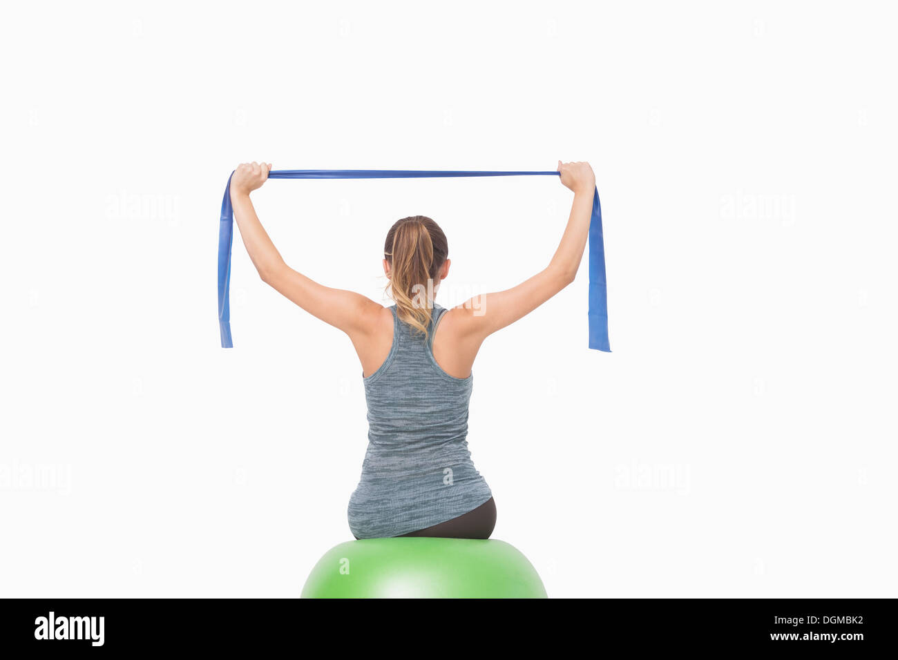 Pferdeschwanz Frau training mit einem Widerstand Band sitzt auf einem Fitness-ball Stockfoto