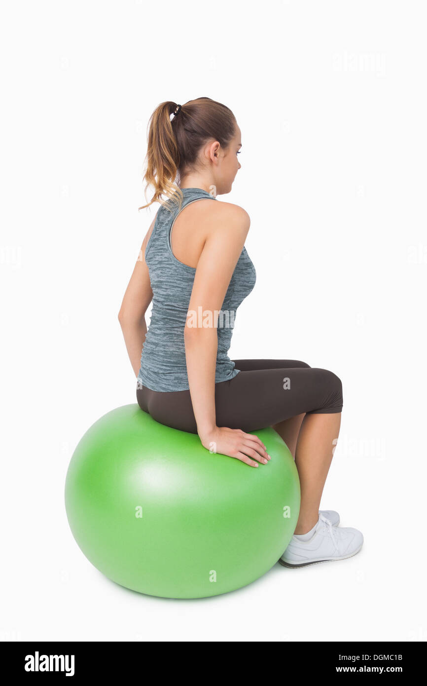 Seitenansicht der Pferdeschwanz Frau sitzen auf Fitness-ball Stockfoto