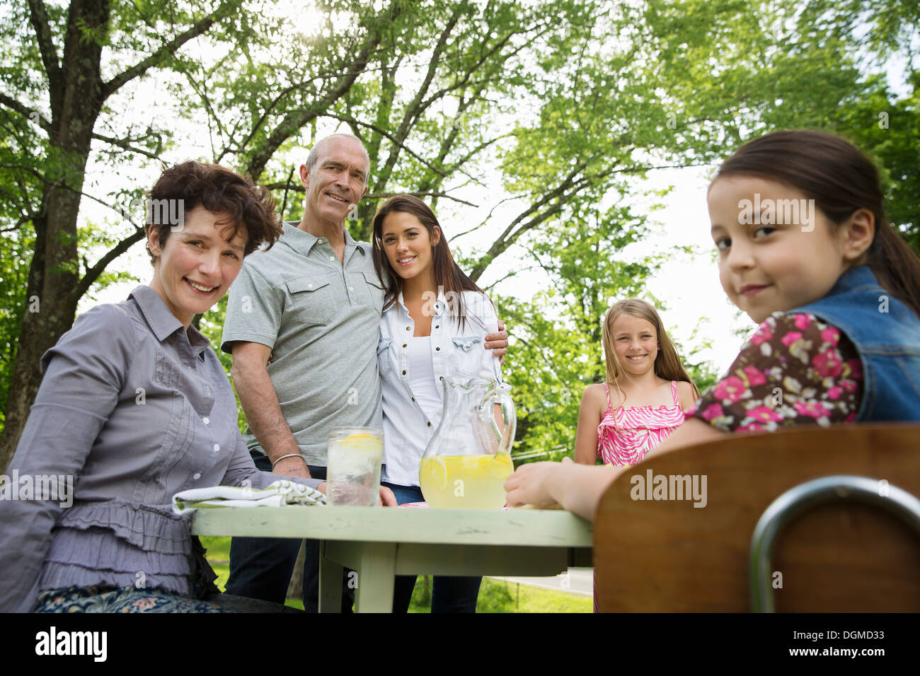 Ein Sommer-Familientreffen auf einem Bauernhof. Eine Familiengruppe, Eltern und Kinder. Frische Limonade zu machen. Stockfoto