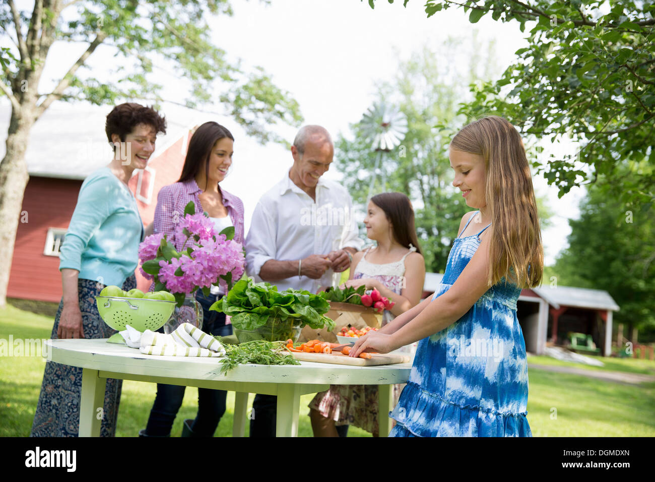 Familienfest. Fünf Personen Tisch bereitet frische Salate Obst Partei zwei Mädchen, eine junge Frau und ein älteres Paar. Stockfoto