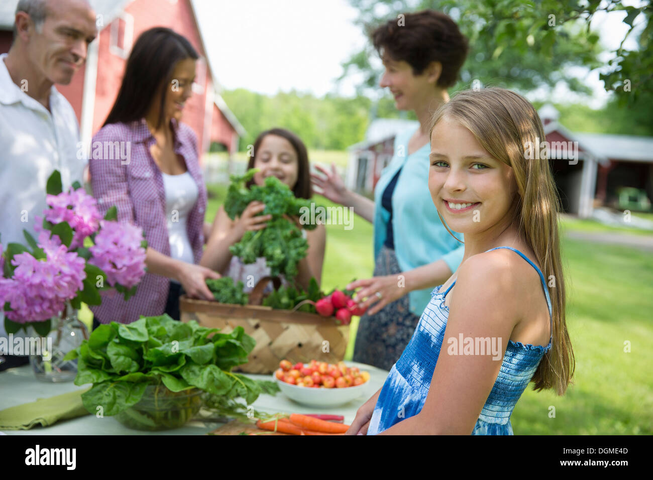 Familienfest. Ein Tisch gedeckt mit Salaten und frischem Obst und Gemüse. Eltern und Kinder. Stockfoto
