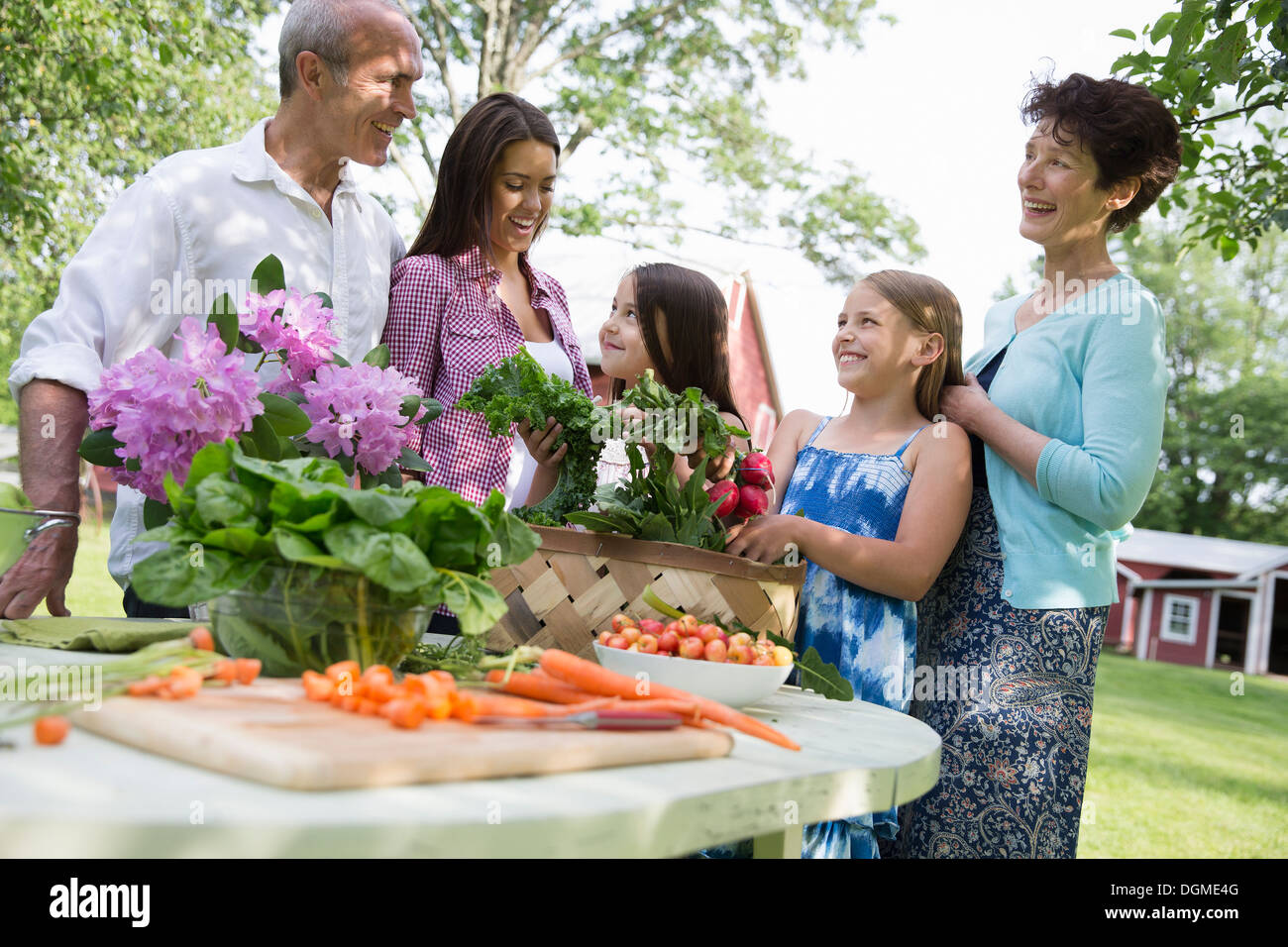Familienfest. Ein Tisch gedeckt mit Salaten und frischem Obst und Gemüse. Eltern und Kinder. Stockfoto