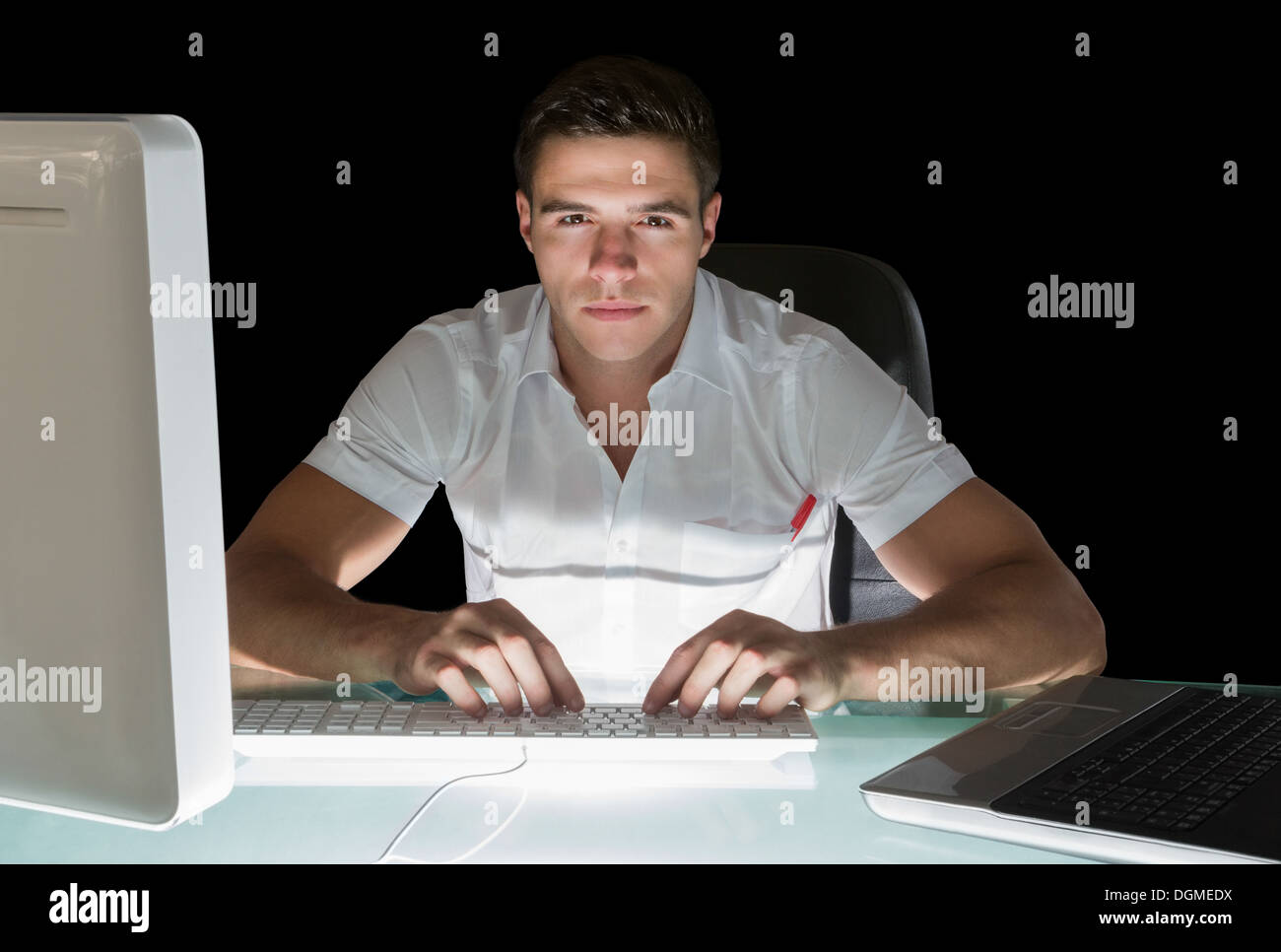 Gut aussehend stirnrunzelnd Computeringenieur arbeitet in der Nacht Stockfoto