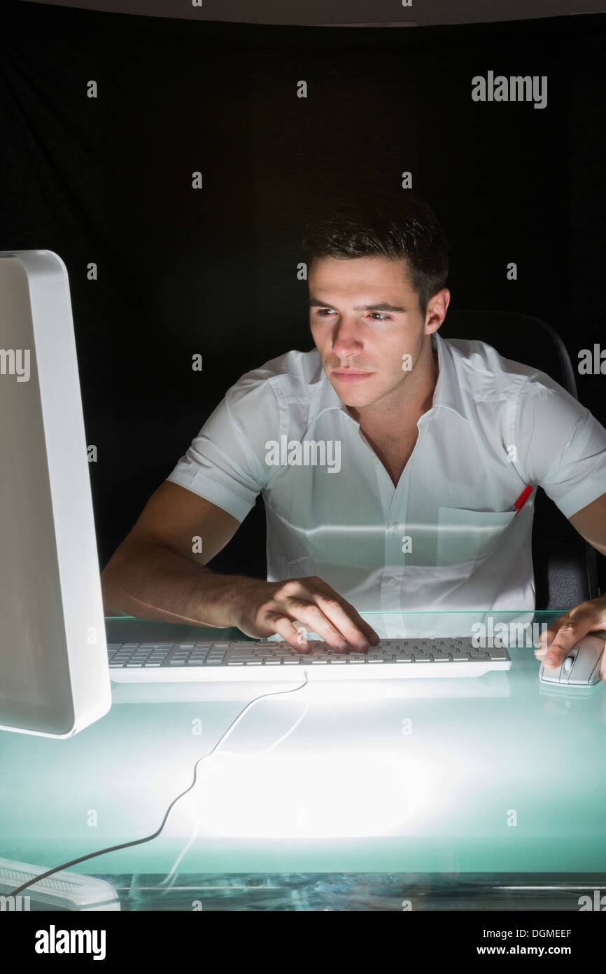 Gut aussehend konzentrierende Computeringenieur arbeitet in der Nacht Stockfoto