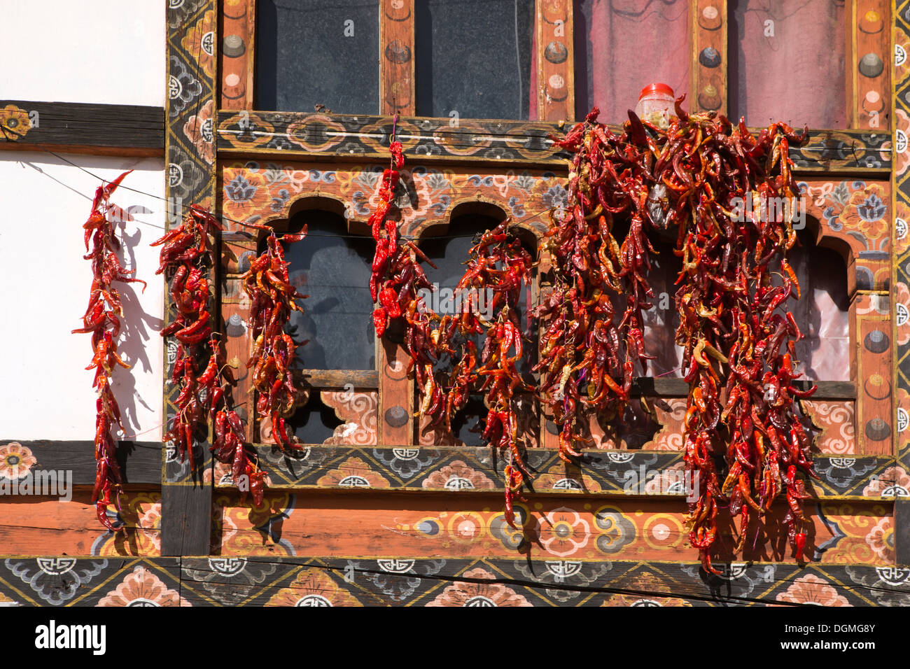 Bhutan, Paro Basar, rote Chilischoten trocknen in der Sonne draußen traditionell verzierte Gebäude Stockfoto