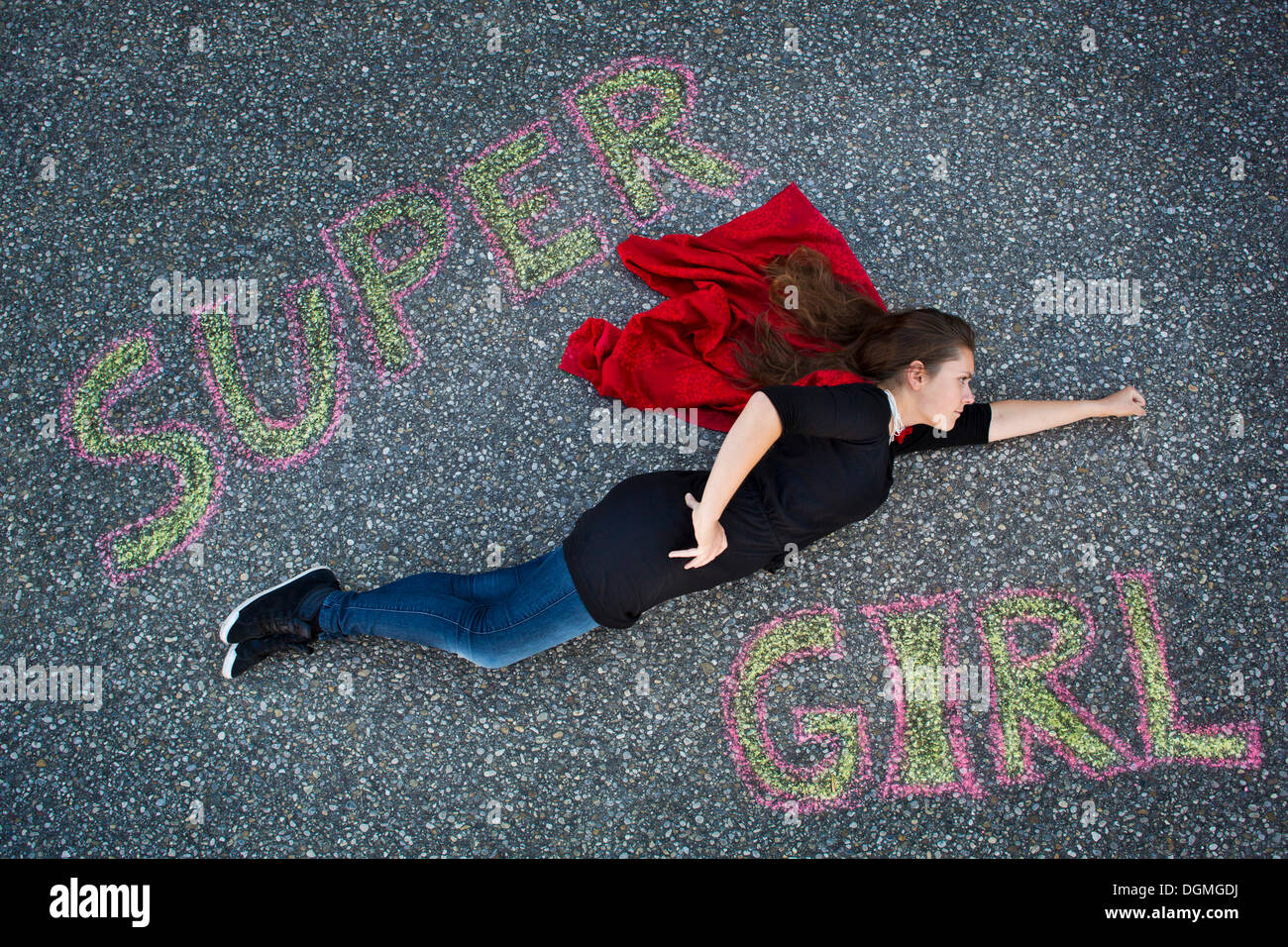 Junge Frau erscheint in einem Superman oder Supergirl Standpunkt, Text "Super Girl" von oben fliegen Stockfoto