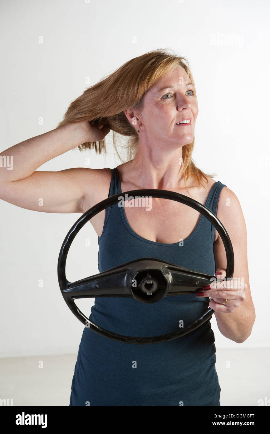 Weiblichen Autofahrer tun ihr Haar am Lenkrad, Blick auf den Spiegel Stockfoto