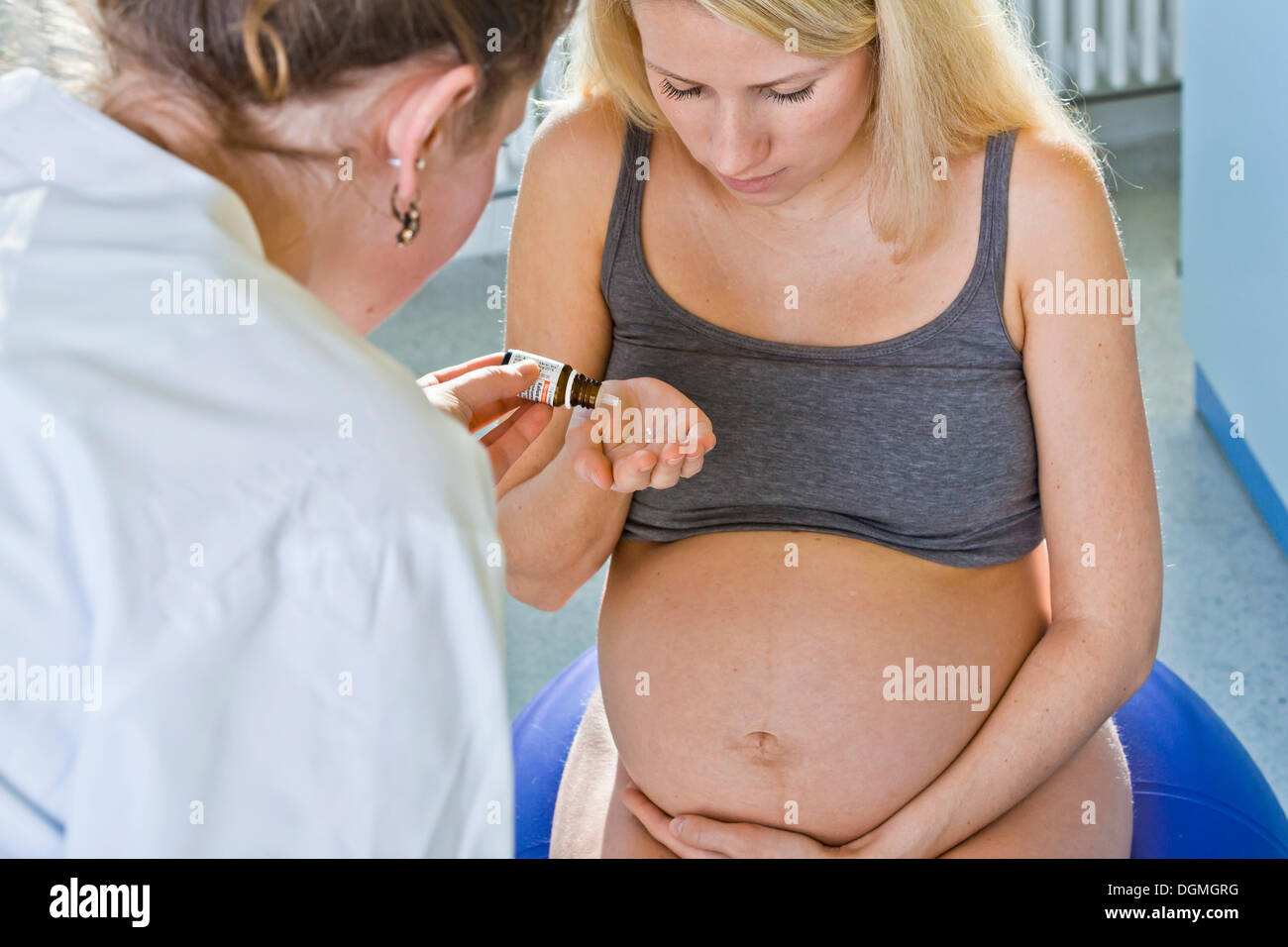 Schwangere Frau, die ihre Hebamme homöopathischen Medizin erhalten, während der Entbindung, Deutschland Stockfoto