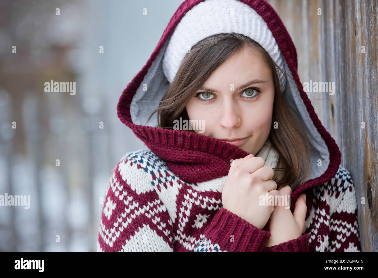 Junge Frau trägt einen gestrickten Pullover mit Kapuze, Porträt, Deutschland Stockfoto
