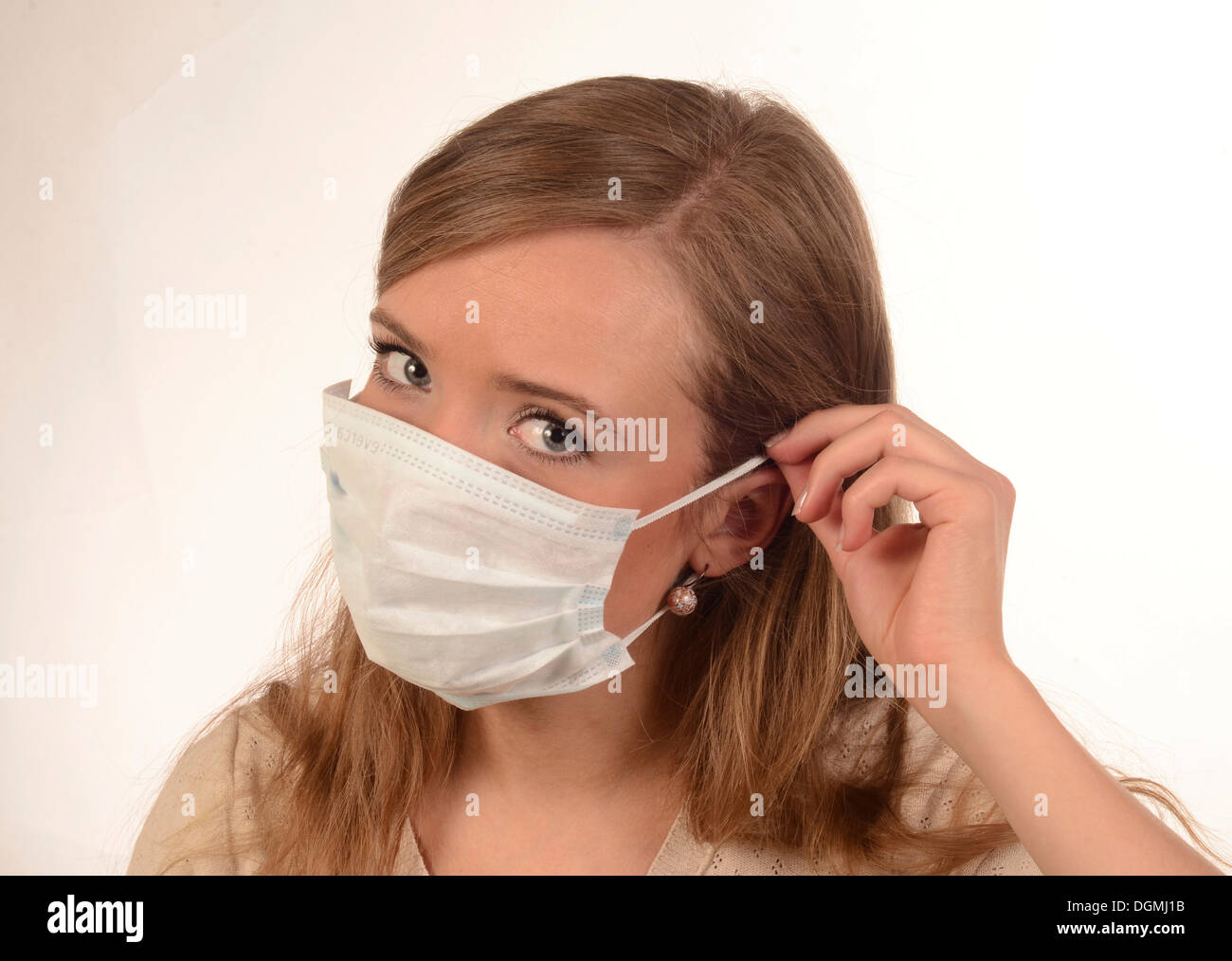 Junge Frau setzt auf eine Gesichtsmaske, Skane, Ystad Stockfoto