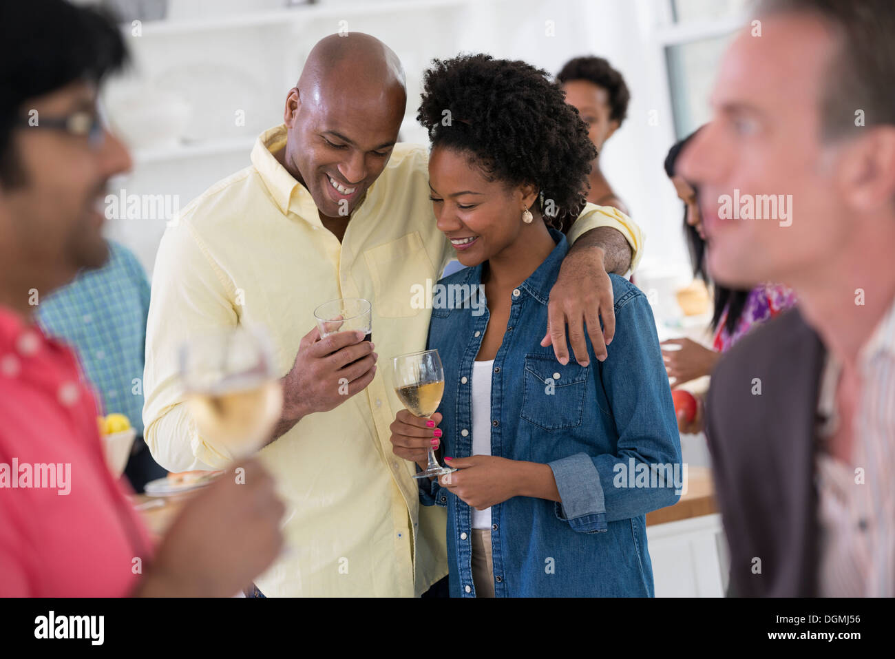 Networking Party oder informelle Veranstaltung. Ein Mann und eine Frau, mit einer Menge um sie herum. Stockfoto
