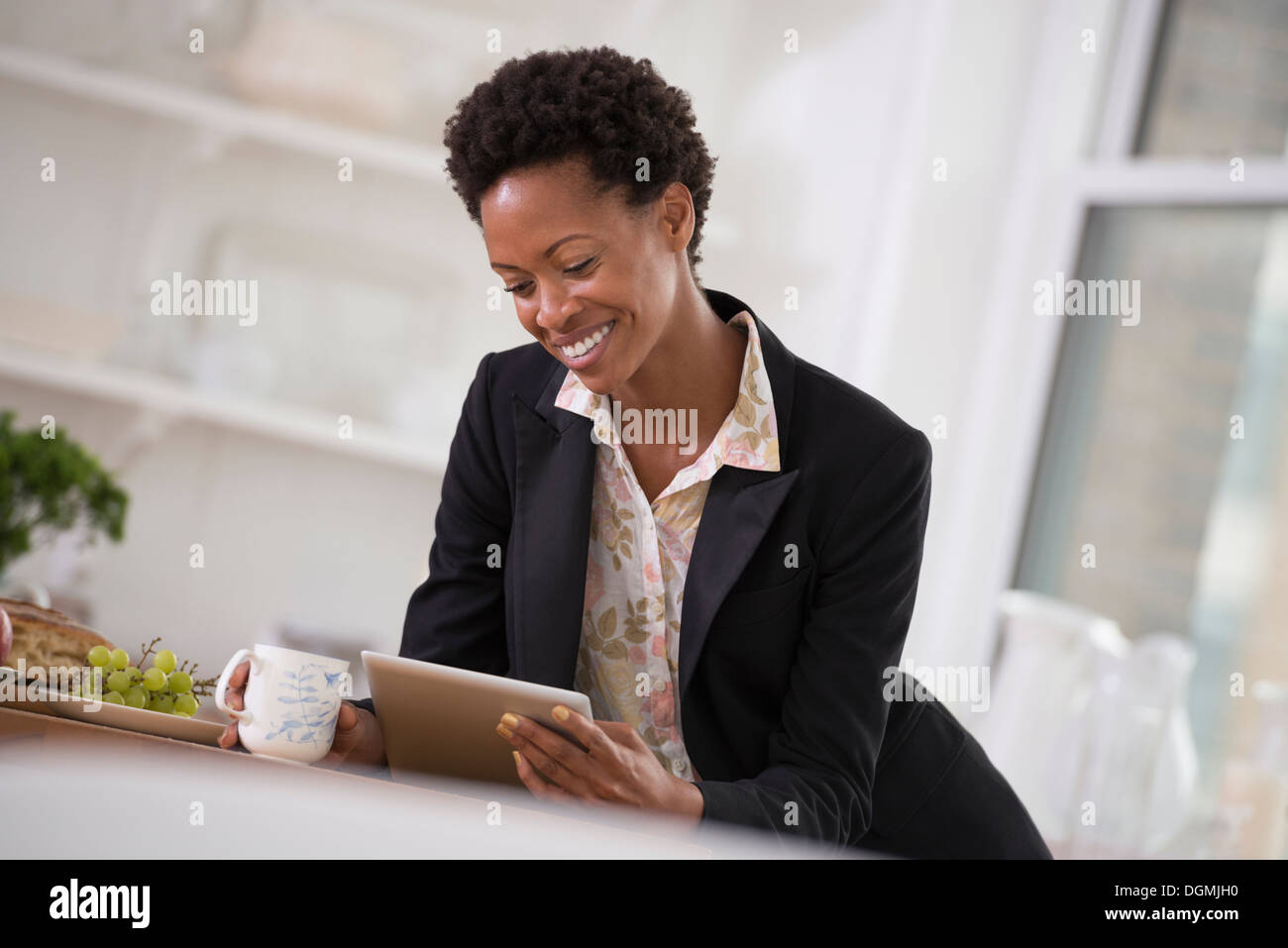 Business-Leute. Eine Frau in einer schwarzen Jacke mit einem digitalen Tablet. Stockfoto