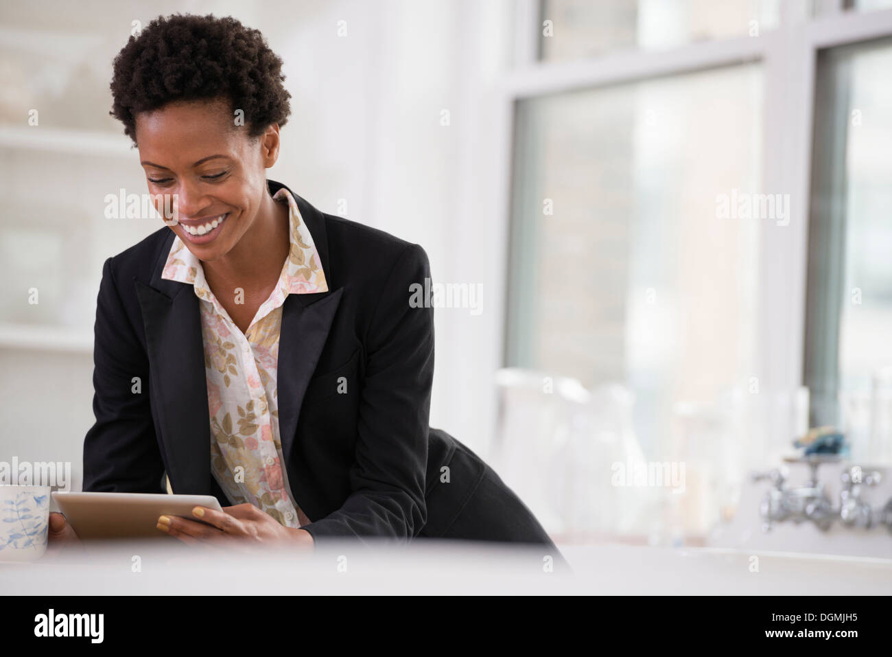 Business-Leute. Eine Frau in einer schwarzen Jacke mit einem digitalen Tablet. Stockfoto