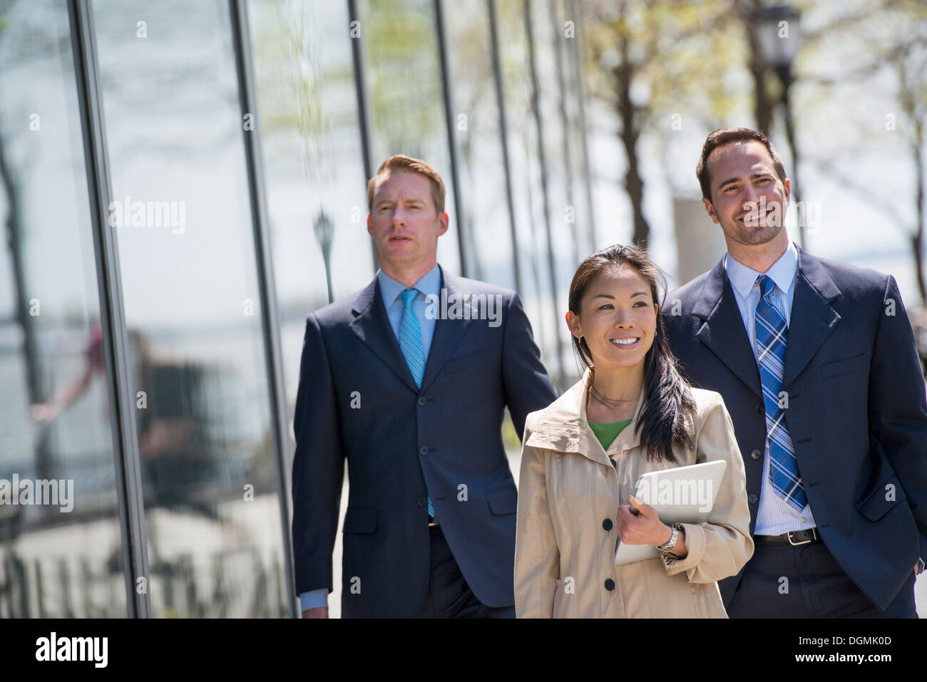 Eine Geschäftsfrau und zwei Geschäftsleute im Freien in der Stadt. Stockfoto