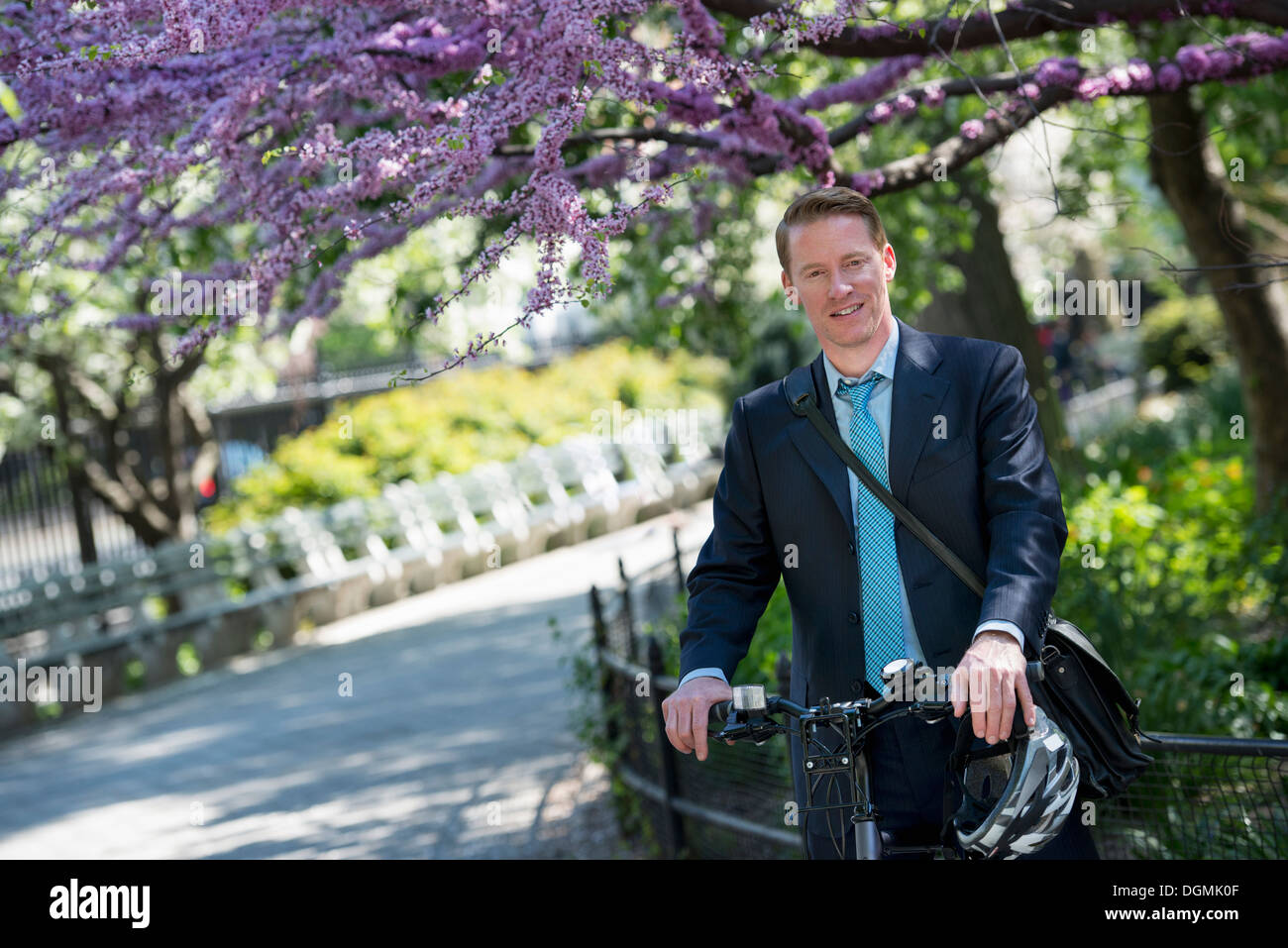Ein Mann im Anzug, mit dem Fahrrad, mit einem Fahrradhelm in seinen Händen. Stockfoto