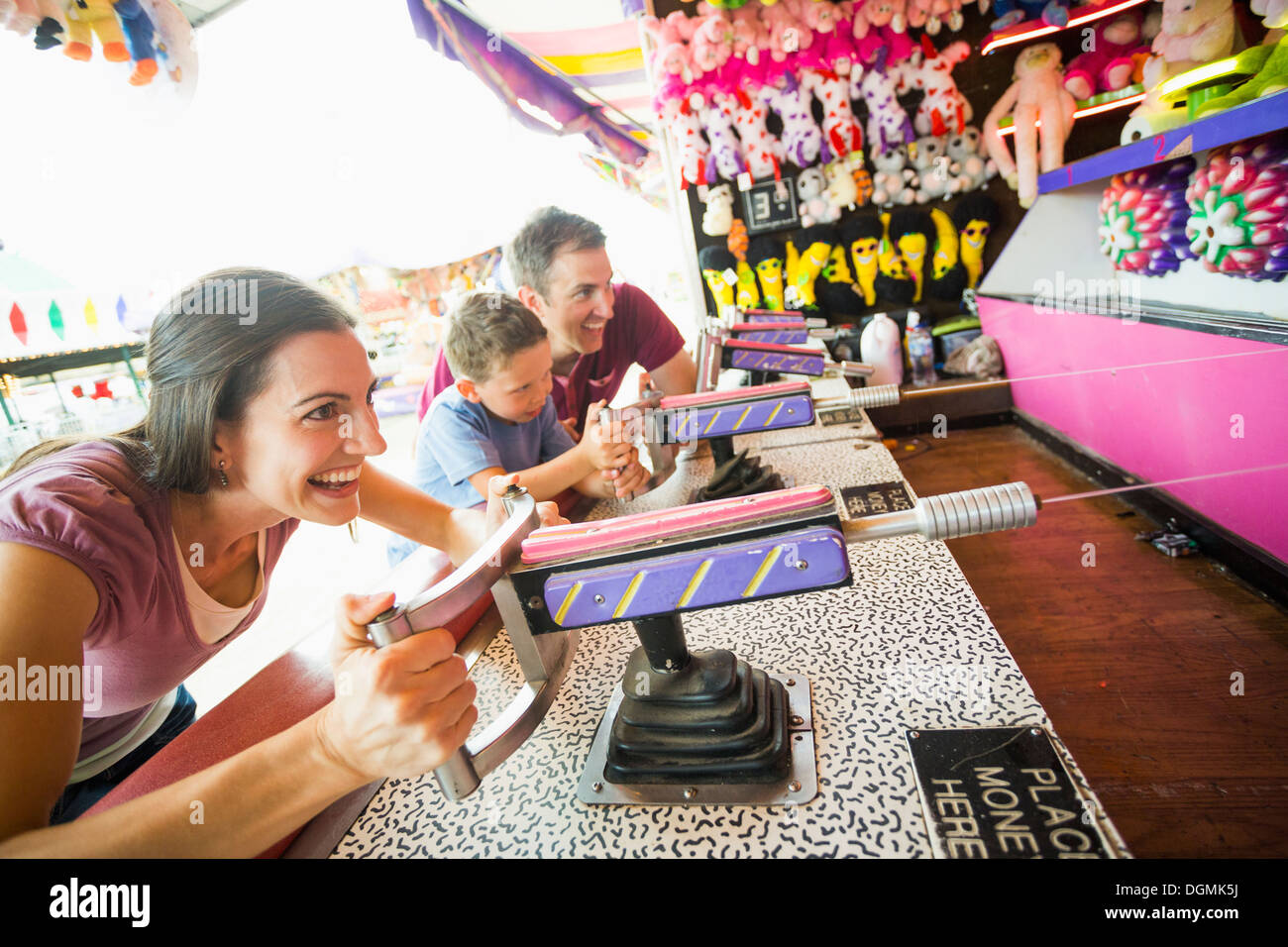 USA, Utah, Salt Lake City, glückliche Familie mit Sohn (4-5) spielen mit Wasserpistole im Vergnügungspark Stockfoto
