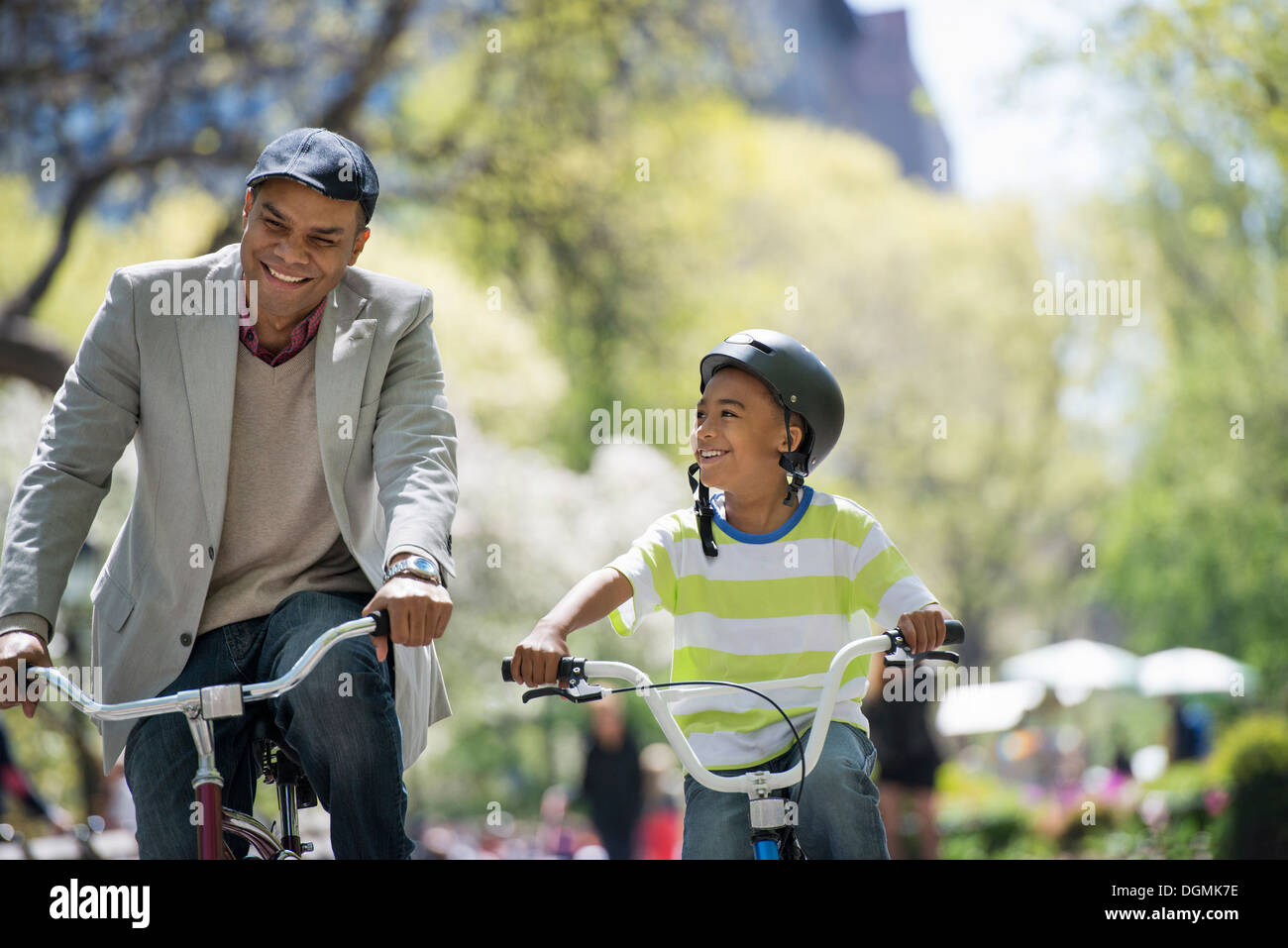 Eine Familie im Park an einem sonnigen Tag. Vater und Sohn, Radfahren Stockfoto