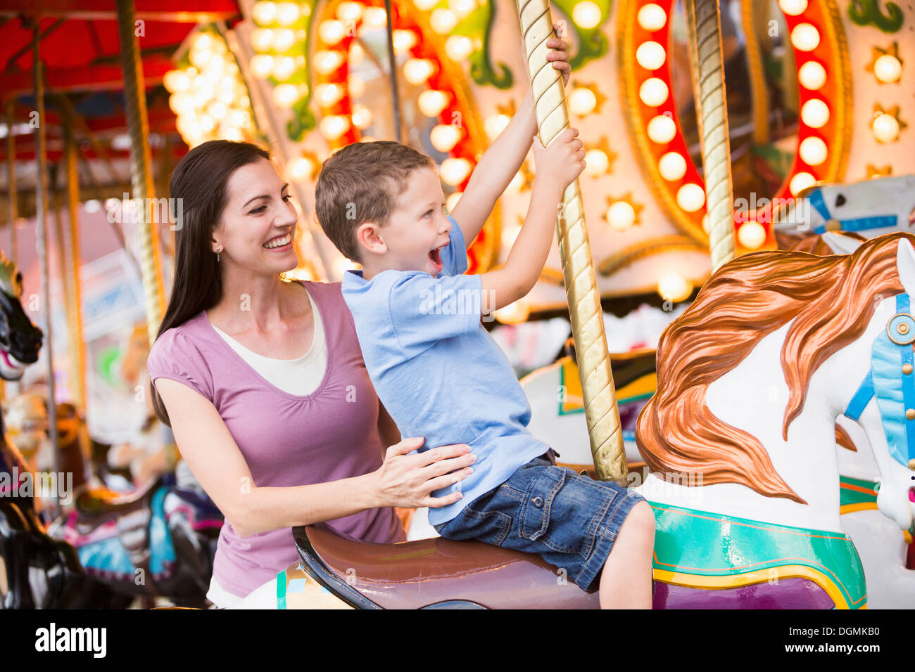 USA, Utah, Salt Lake City, Mutter und Sohn (4-5) auf Karussell im Vergnügungspark Stockfoto