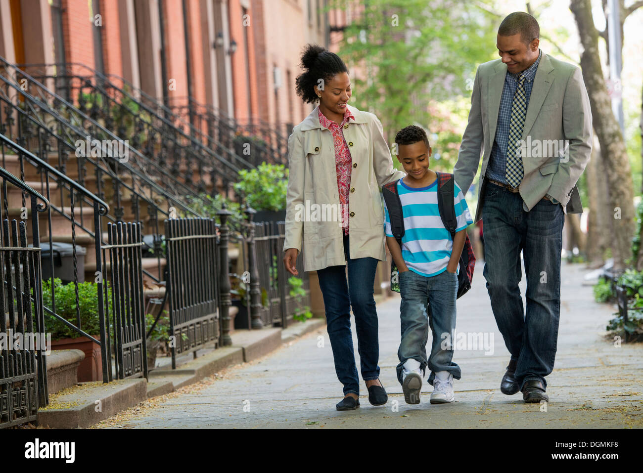 Eine Familie im Freien in der Stadt. Zwei Eltern und ein kleiner Junge zusammen spazieren. Stockfoto