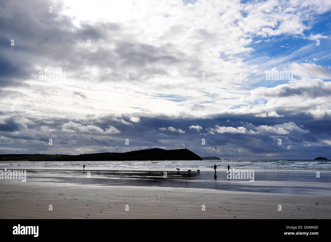 North Cornwall - Polzeath Strand - Blick auf Sand und Wellen, Stepper Point - dunklen Umriss - türmenden Wolken - blau-weiß-grau Stockfoto