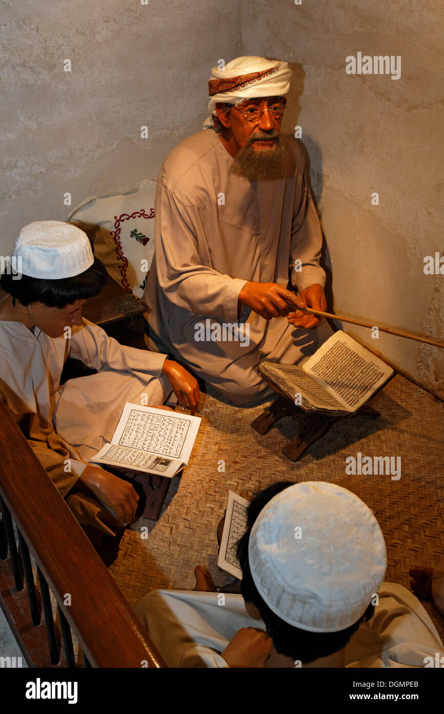 Arabische Lehrer unterrichten von Schülern beim Sitzen auf den Boden, lebensgroße Figuren, Al Ahmadiya School Museum, Dubai Stockfoto
