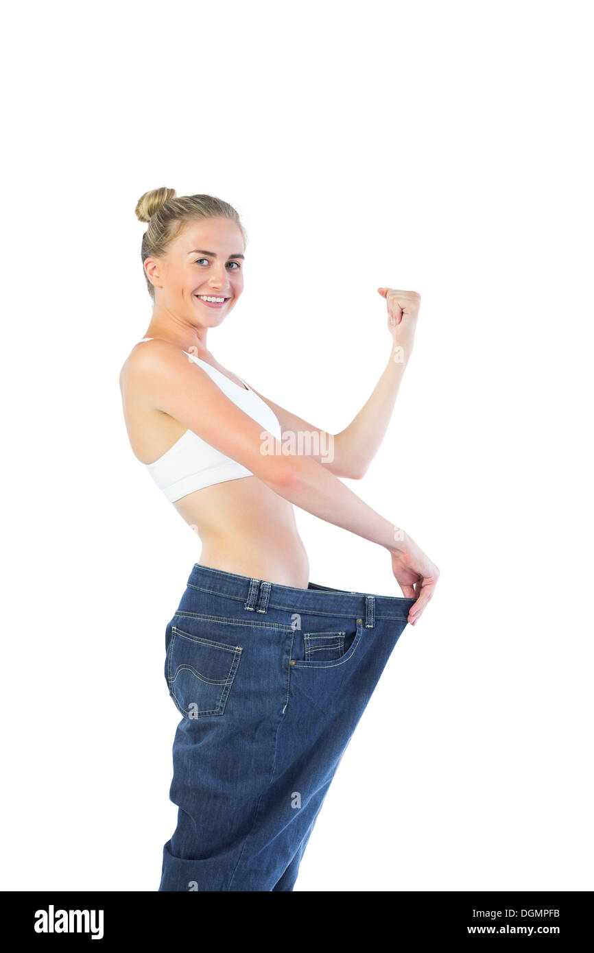 Zuversichtlich triumphalen Blondine zu groß Hosen Stockfoto