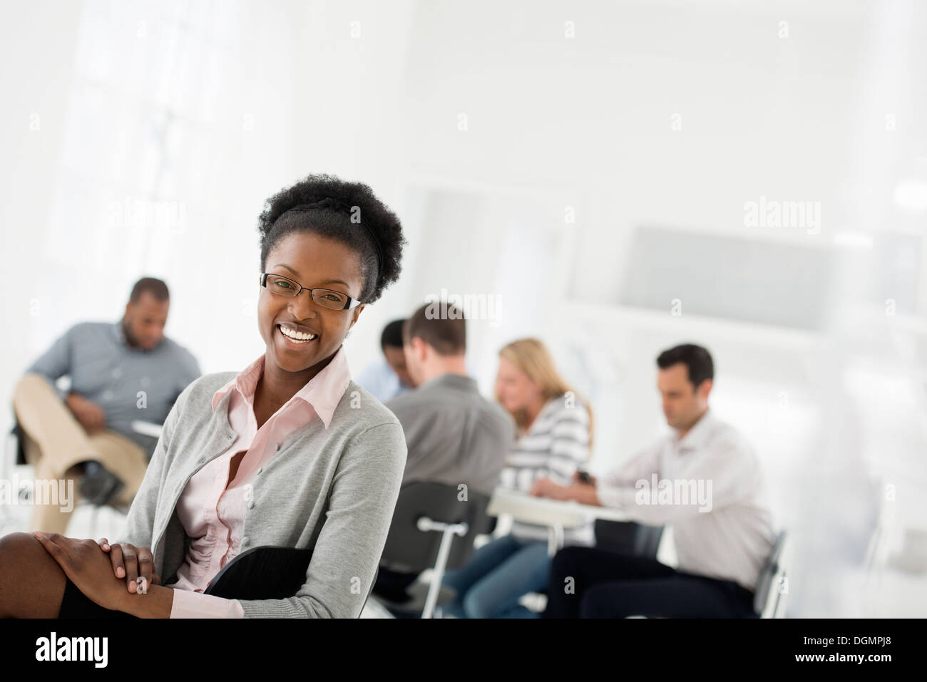 Büroeinrichtung. Eine Gruppe von Menschen treffen. Eine Person, die auf der Suche über die Schulter und von der Gruppe entfernt. Stockfoto