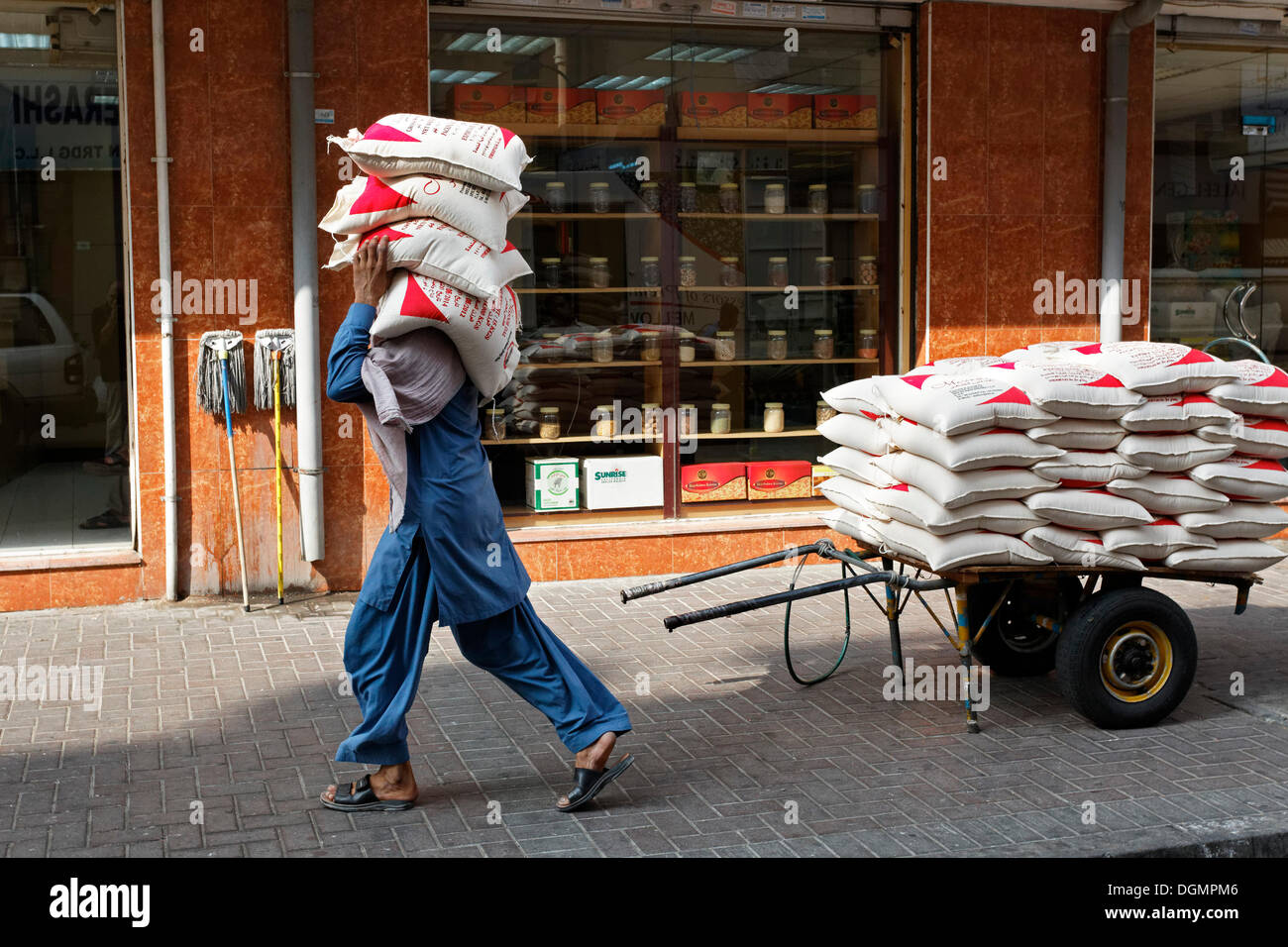 Arbeiter tragen Säcke mit Linsen auf seine Schulter, Deira, alte Souk, Dubai, Vereinigte Arabische Emirate, Naher Osten Stockfoto