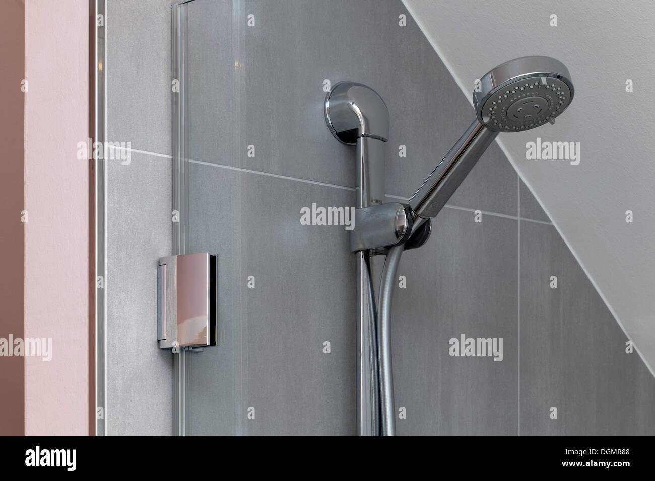 Duschkopf in der Dusche auf gefliesten Wand Stockfoto