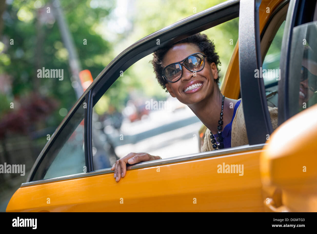 Eine Frau aus dem hinteren Beifahrersitz ein yellow Cab. Stockfoto