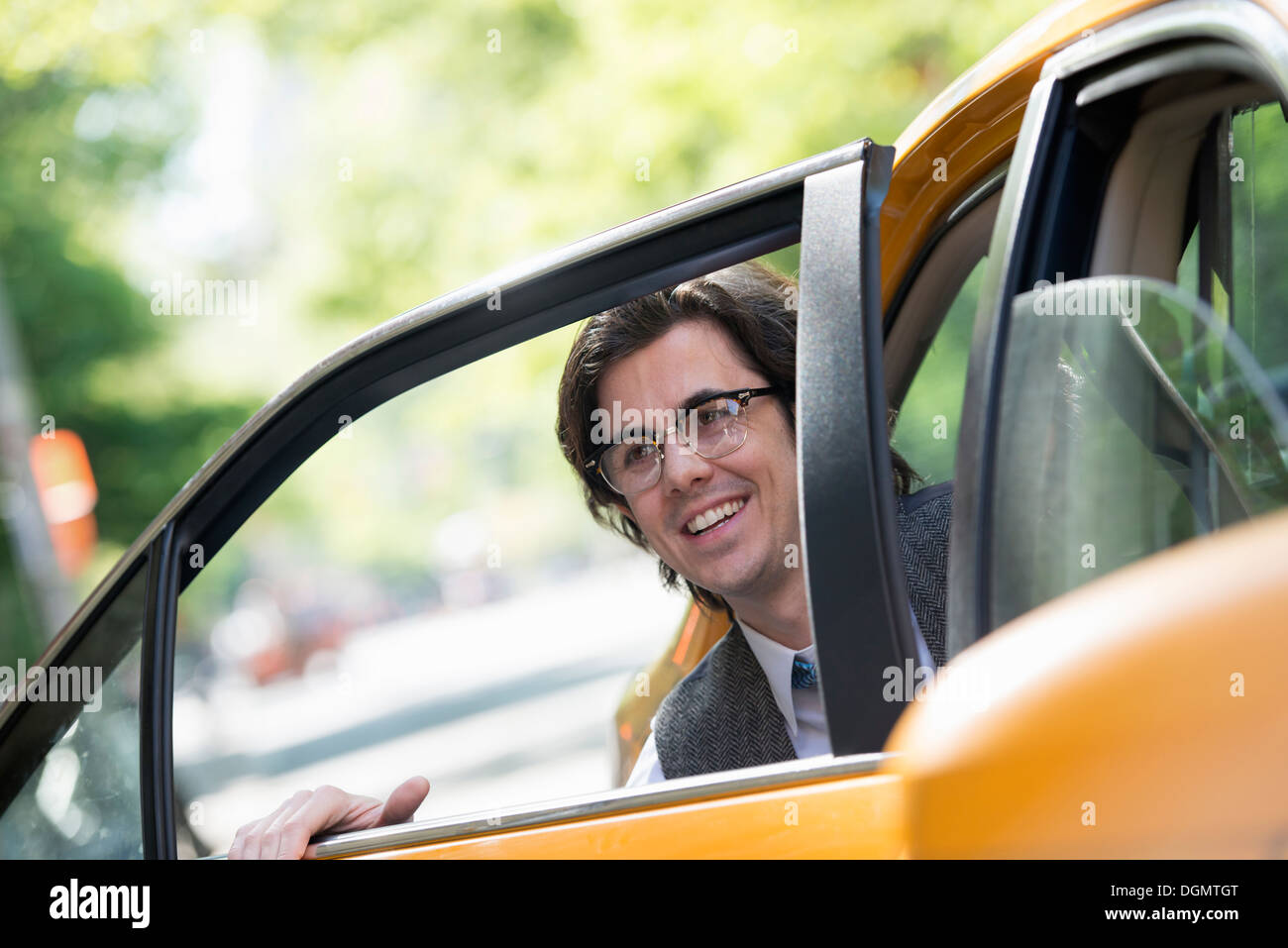 Leben in der Stadt. Menschen in Bewegung. Ein junger Mann auf dem Rücksitz eines Taxis. Stockfoto