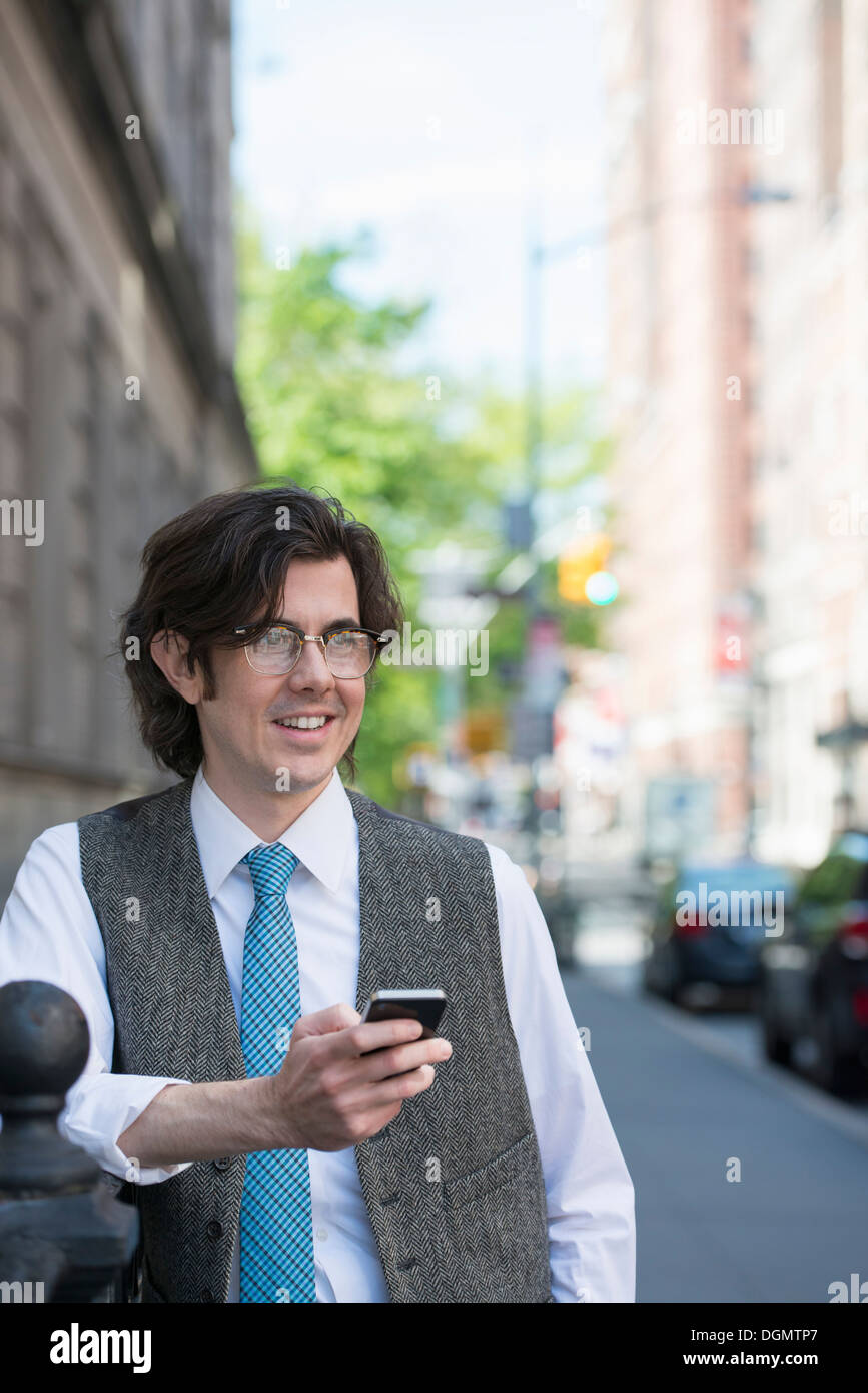 Ein junges Unternehmen Mann auf der Straße sein Smartphone überprüfen. Stockfoto