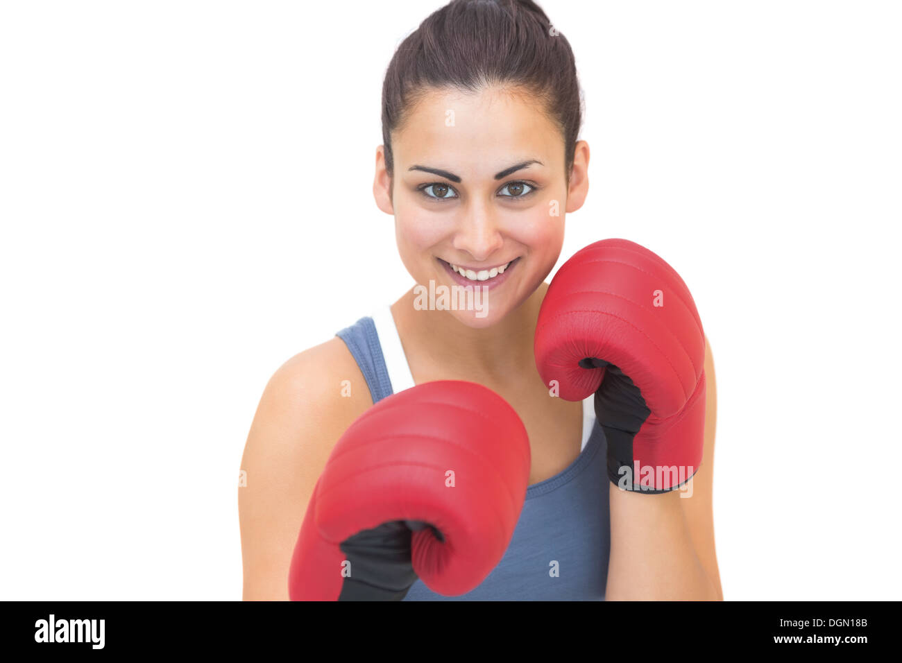 Lächelnde sportliche Brünette tragen rote Boxhandschuhe Stockfoto