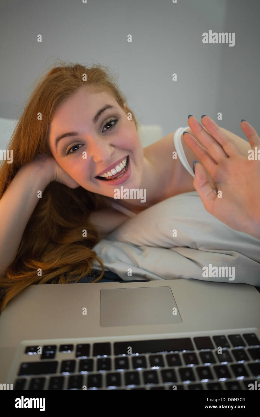 Glücklich Rothaarige winken für Laptop auf video-chat Stockfoto