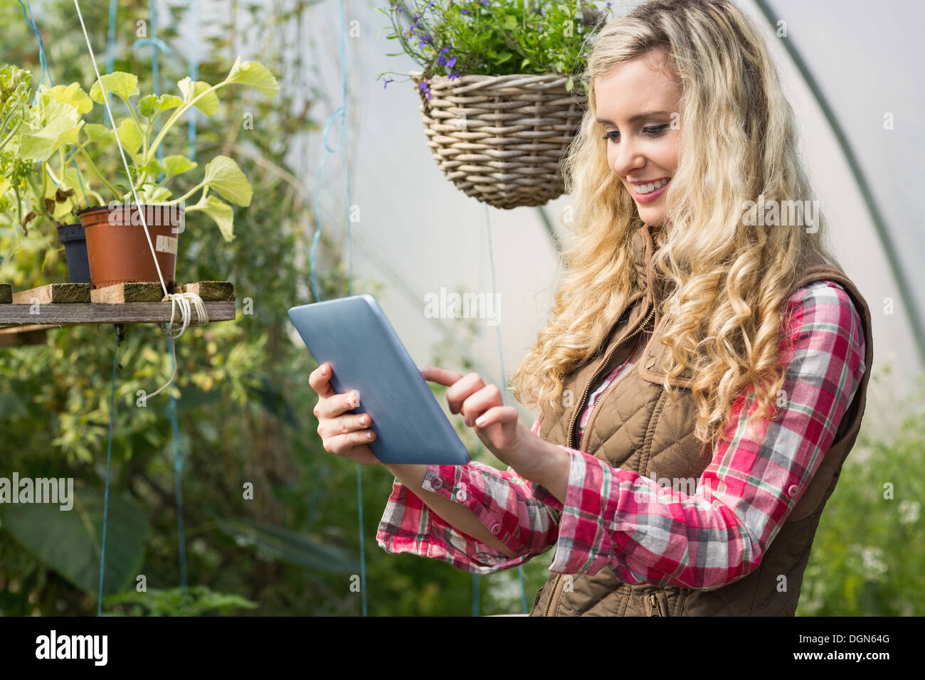 Hübsche Frau mit ihrem Tablet in ein grünes Haus Stockfoto