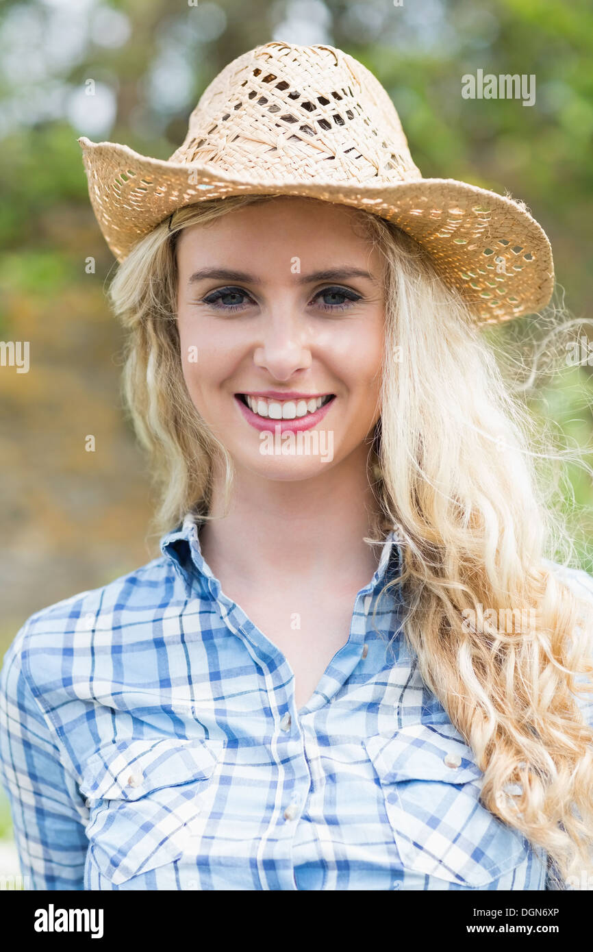 Lächelnde Frau trägt einen Strohhut Stockfoto
