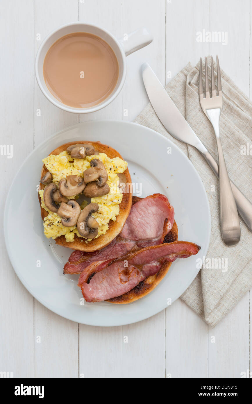 Ei, Speck und Pilzen Bagel, mit einer Tasse Tee. Stockfoto