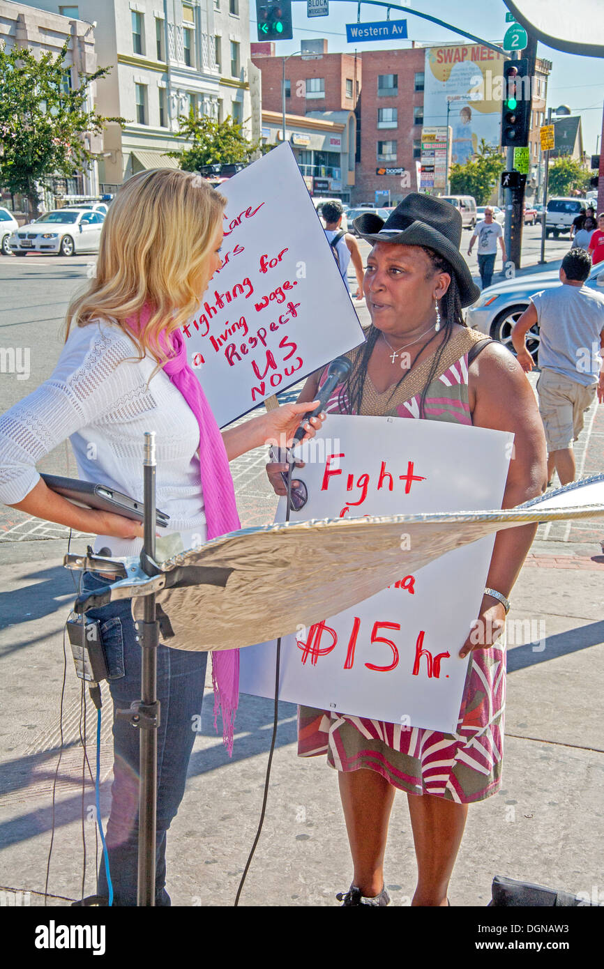 Eine Fernsehübertragung Journalist Interviews ein Teilnehmer an einer Demonstration der Fast-Food-Arbeitnehmer in Los Angeles. Stockfoto
